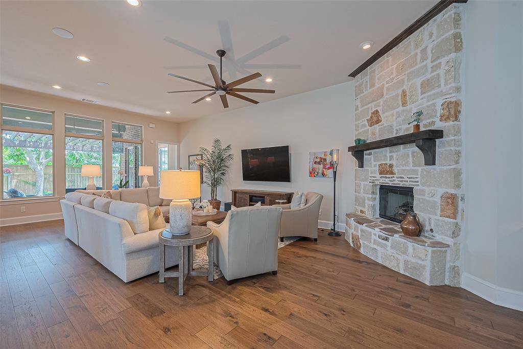 This inviting family room offers comfort and style, featuring recessed lighting, a charming rustic stone fireplace, and an updated ceiling fan that adds a modern touch.  And, this room has surround sound for an amazing movie night.