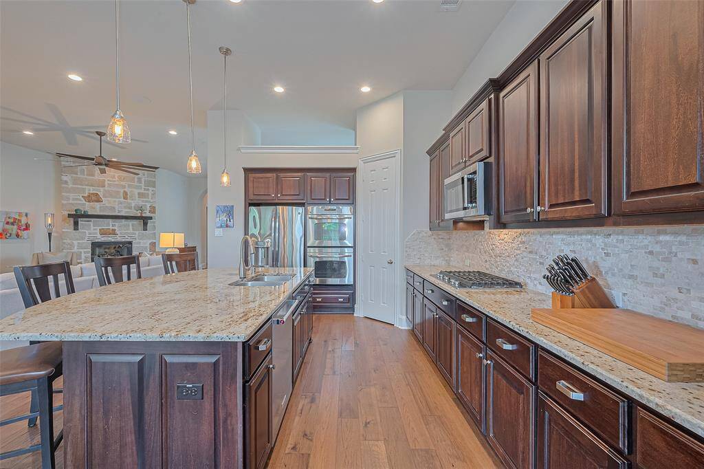 Take in the view of this well-appointed kitchen, featuring a spacious granite island, double ovens, a walk-in pantry, and a gas cooktop. The refrigerator is included, and there’s ample cabinet and counter space to meet all your cooking and storage needs.