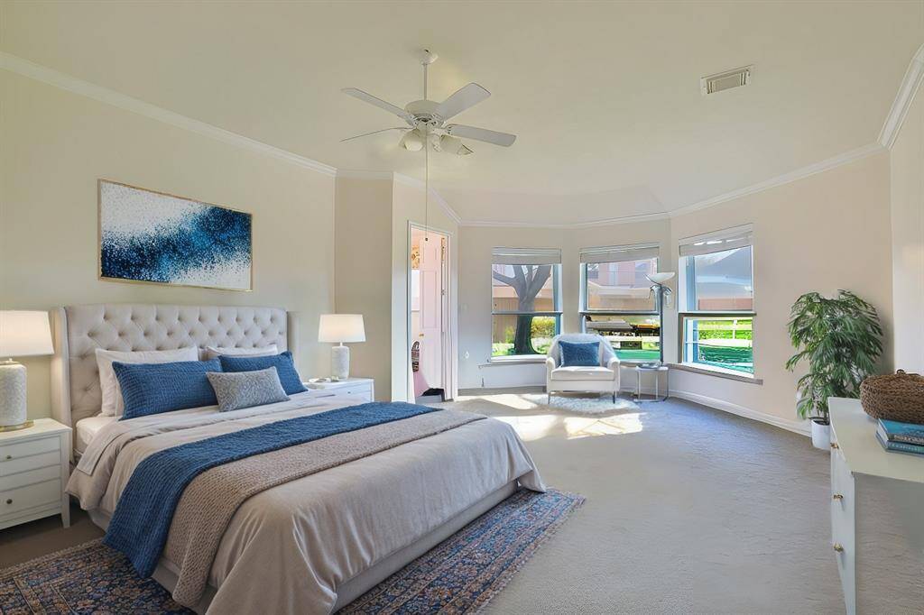 PRIMARY BEDROOM OFFERS PLUSH CARPETING, CROWN MOLDING, AND THE ENSUITE BATHROOM IS JUST STEPS AWAY, ENSURING BOTH COMFORT AND CONVENIENCE.