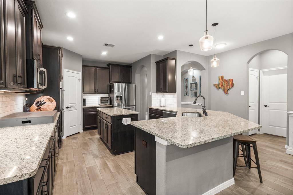 This exceptional kitchen is designed to impress even the most discerning chef. Thoughtful features include pull out trash bin, deep storage drawers for pots & pans, pull-out wire shelving in the cabinets, and recessed work lighting. The deep sink is as functional as it is stylish and offers a pull-out sprayer and filtered water dispenser, adding both style and convenience.