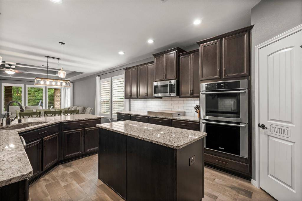 A pristine showcase of elegance and function, this extraordinary kitchen features stainless steel appliances, including a 5-burner gas cooktop, double convection ovens, whisper-quiet dishwasher, and microwave.  Designed for both gourmet cooking and sophisticated entertaining, this kitchen is truly the heart of the home.