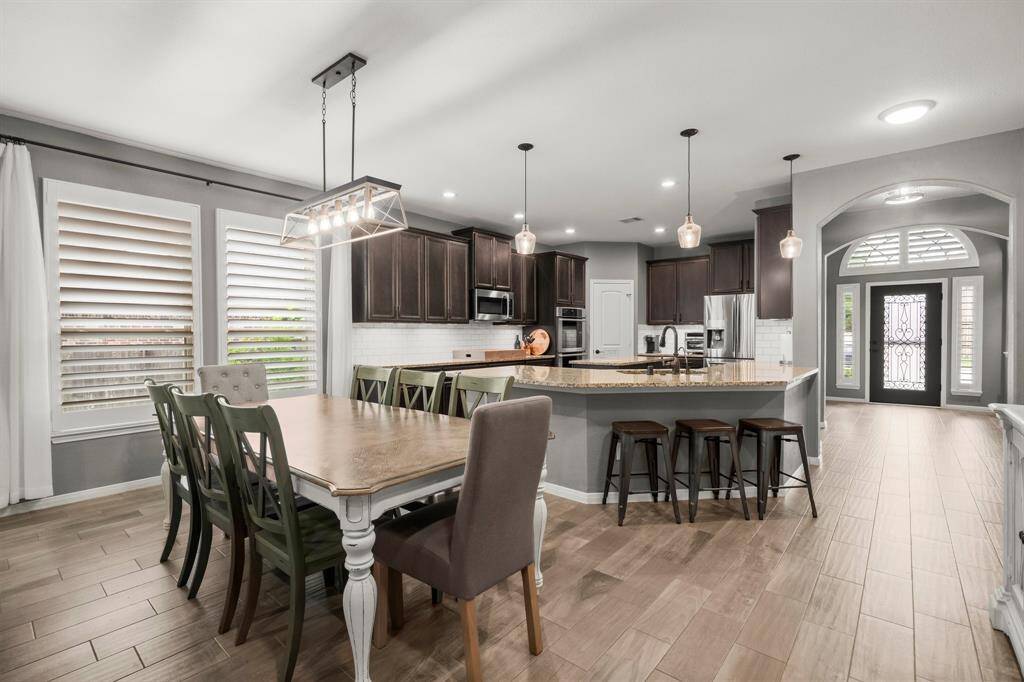 This gorgeous living and kitchen area is an entertainer’s dream! With an open floor plan, conversation flows effortlessly between the kitchen, den, and dining room—perfect for hosting or enjoying time with loved ones. Extra-large picture windows bring in natural light and add to the home’s inviting ambiance.