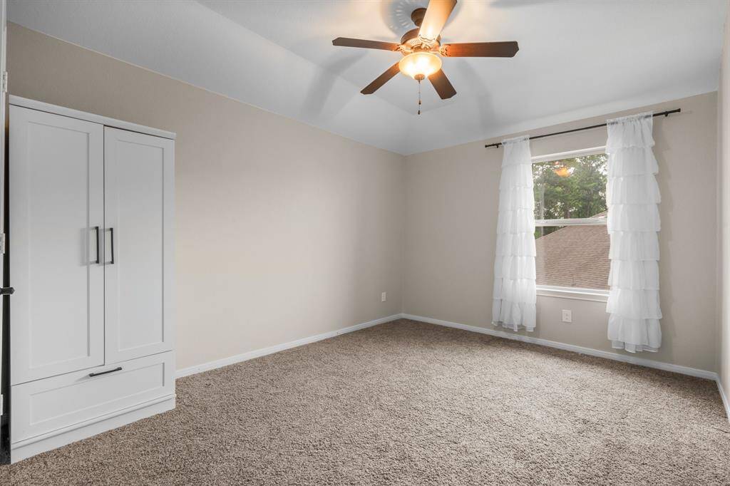 Two additional secondary bedrooms are located in another area for privacy. This bedroom offers lush carpeting, sloped ceiling, walk-in closet, sunny window, and lighted ceiling fan. It has hallway access to a full bath shared with Bedroom 4 and attic access in the closet.