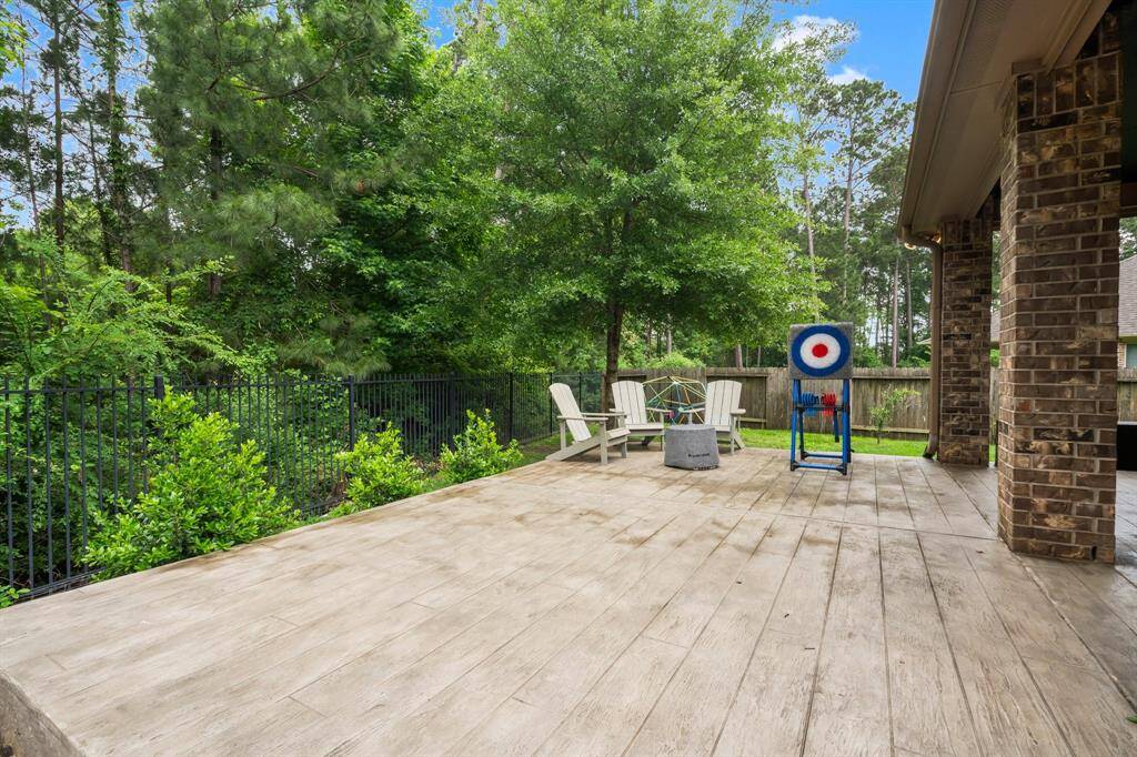 This open area of the patio is perfect for games or outdoor living/dining space. As the sun dips below the trees, soak in the serene woodland views and create lasting memories with family and friends.