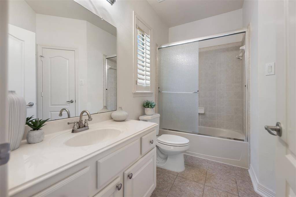 The ensuite bath offers a sleek tub-shower combo, perfect for relaxation or a quick rinse. It also includes a spacious walk-in closet for ample storage, along with a convenient linen closet for added organization.