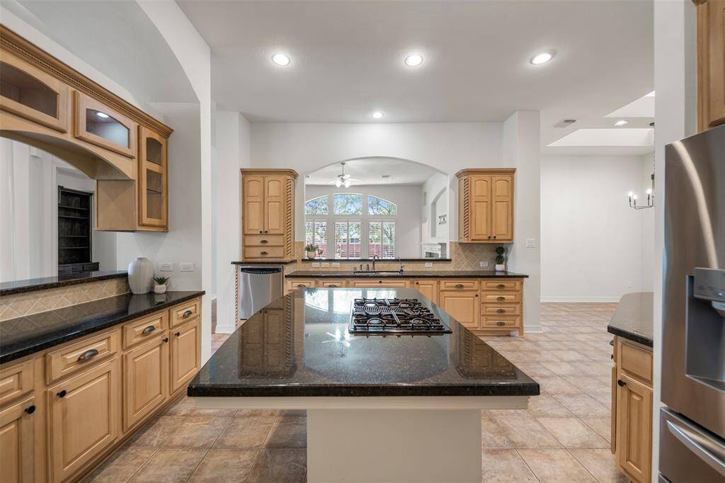 The kitchen features arched cut-out openings that offer charming views into the living room, adding architectural interest and an open, connected feel.