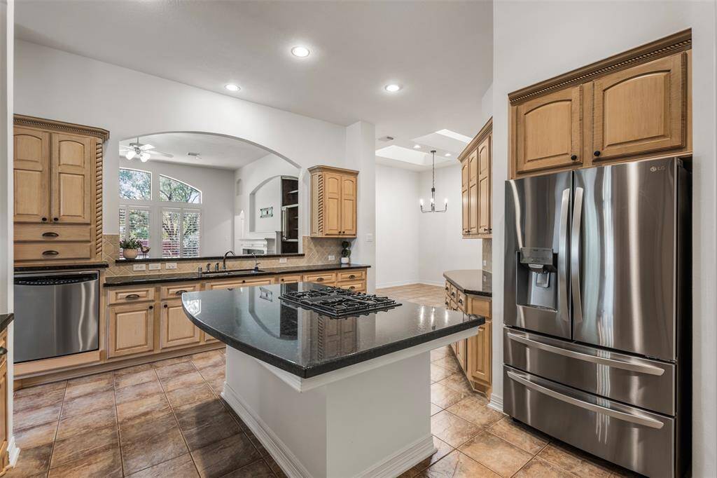 This well-appointed kitchen showcases stainless steel appliances, an oversized island with a gas cooktop, blending style and function seamlessly.