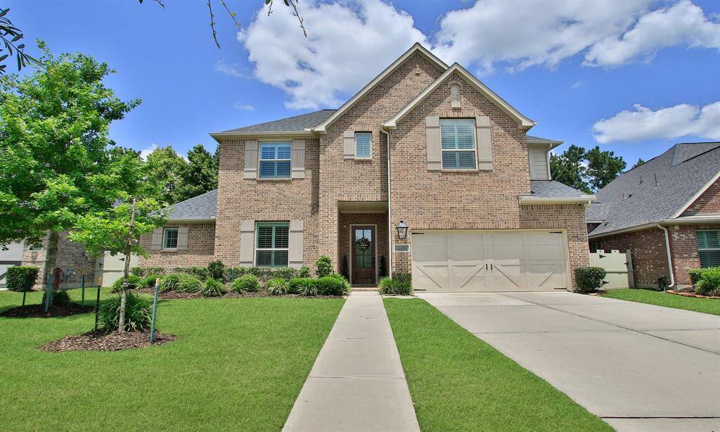 Welcome Home to 9975 Preserve Way. This photo showcases a charming two-story brick home with a neatly manicured lawn, a spacious driveway leading to a two-car garage, and a welcoming front entrance. The house is set against a picturesque sunset sky, enhancing its curb appeal.