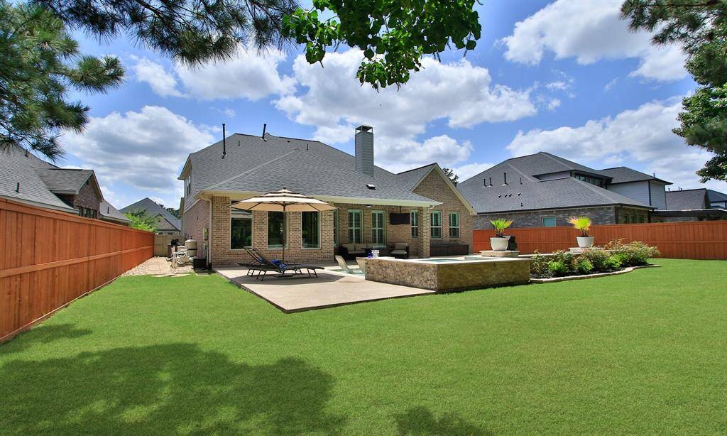 Welcome Home to 9975 Preserve Way. This photo showcases a charming two-story brick home with a neatly manicured lawn, a spacious driveway leading to a two-car garage, and a welcoming front entrance. The house is set against a picturesque sunset sky, enhancing its curb appeal.