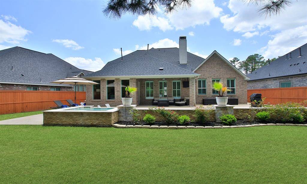 Welcome Home to 9975 Preserve Way. This photo showcases a charming two-story brick home with a neatly manicured lawn, a spacious driveway leading to a two-car garage, and a welcoming front entrance. The house is set against a picturesque sunset sky, enhancing its curb appeal.