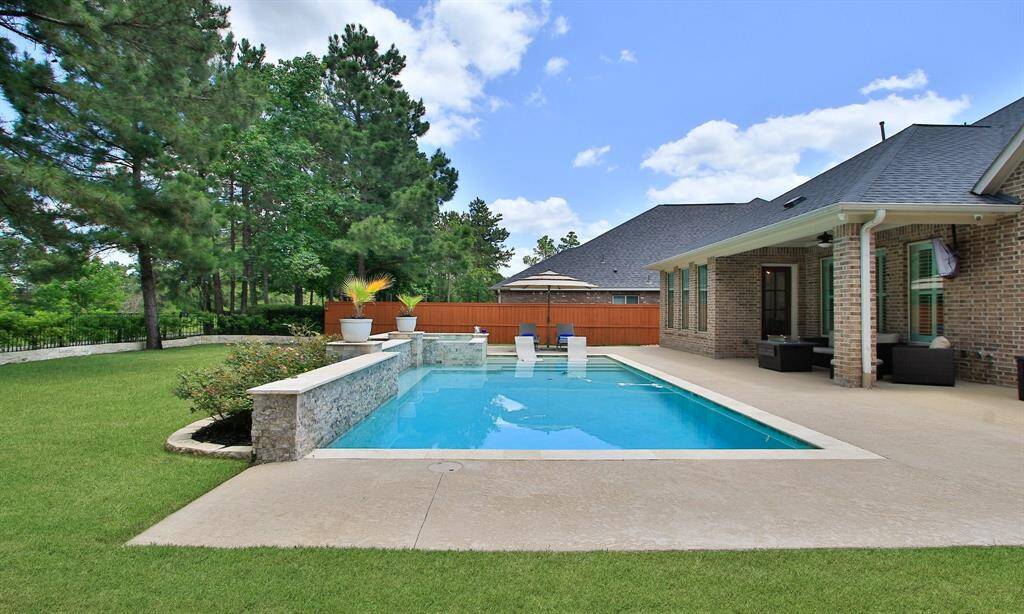 Welcome Home to 9975 Preserve Way. This photo showcases a charming two-story brick home with a neatly manicured lawn, a spacious driveway leading to a two-car garage, and a welcoming front entrance. The house is set against a picturesque sunset sky, enhancing its curb appeal.