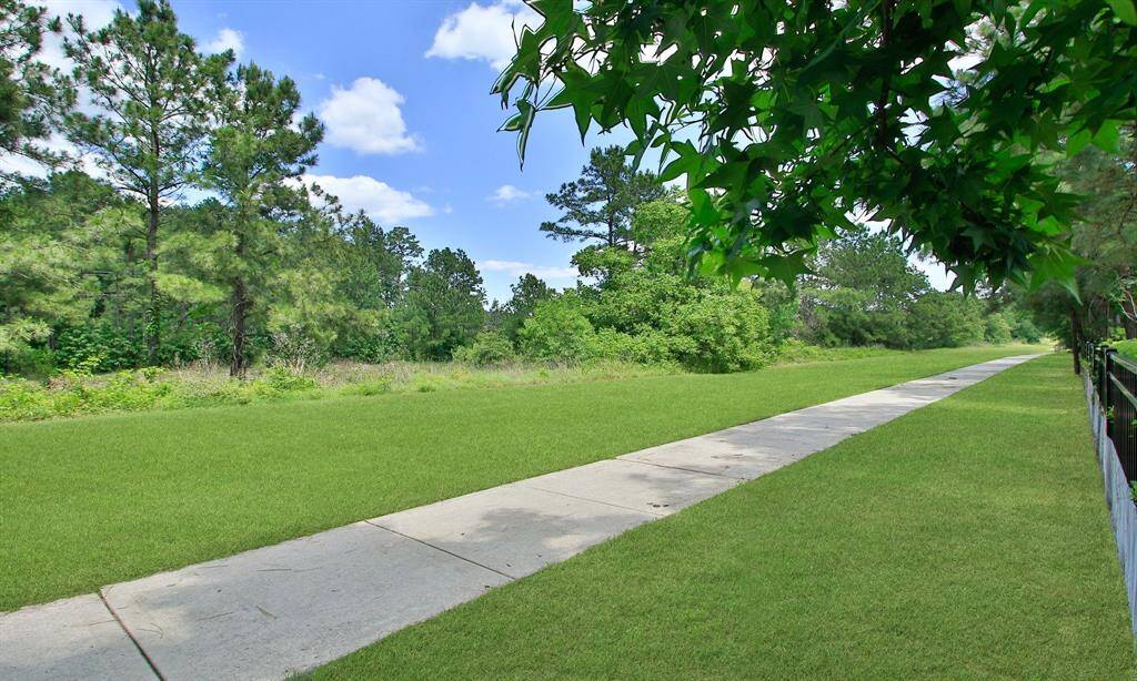 Welcome Home to 9975 Preserve Way. This photo showcases a charming two-story brick home with a neatly manicured lawn, a spacious driveway leading to a two-car garage, and a welcoming front entrance. The house is set against a picturesque sunset sky, enhancing its curb appeal.