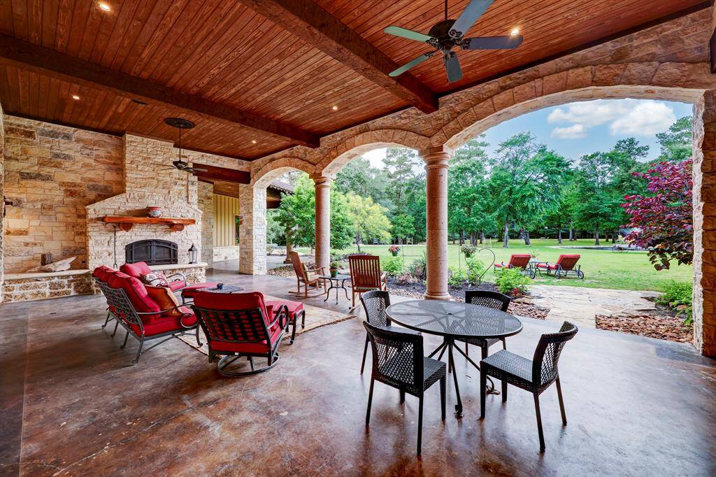 The outdoor covered patio has ample seating room, ceiling fans, and an outdoor wood burning fireplace.