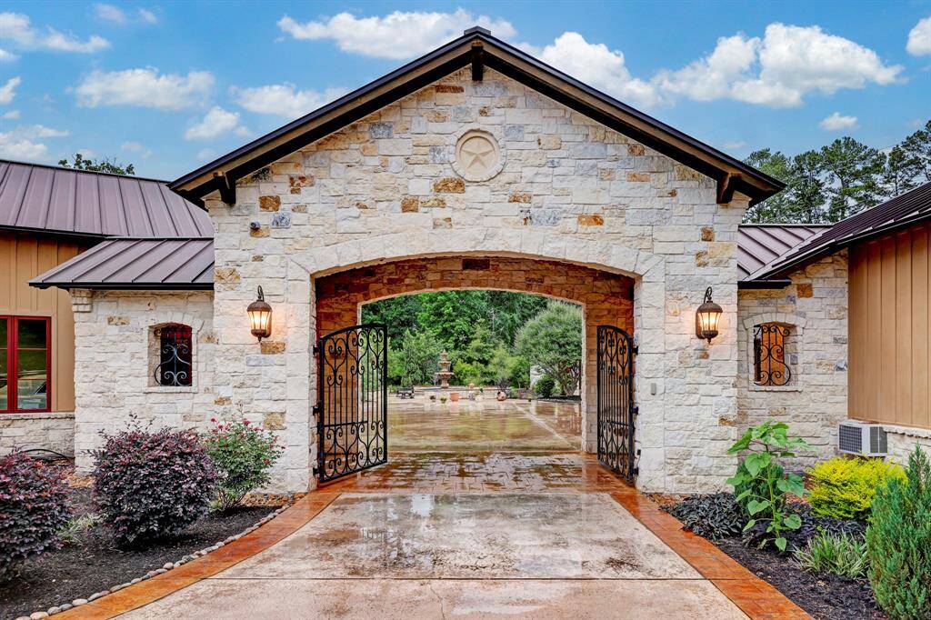The driveway entrance boasts a custom designed dual iron front gate.