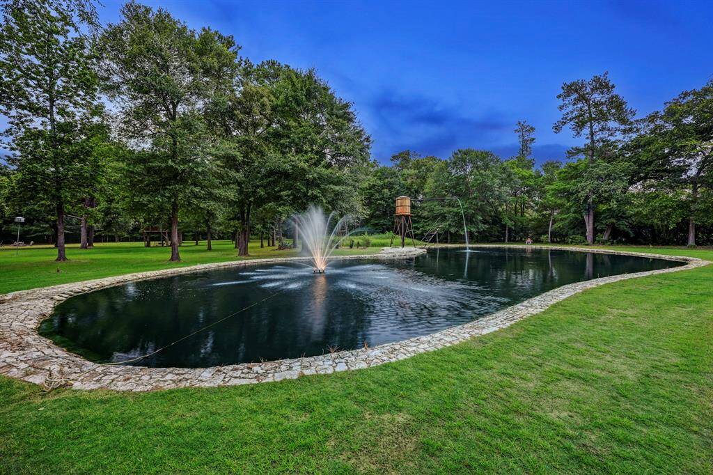 The 12 foot deep pond with stone lined exterior includes a fountain and water tower feature.