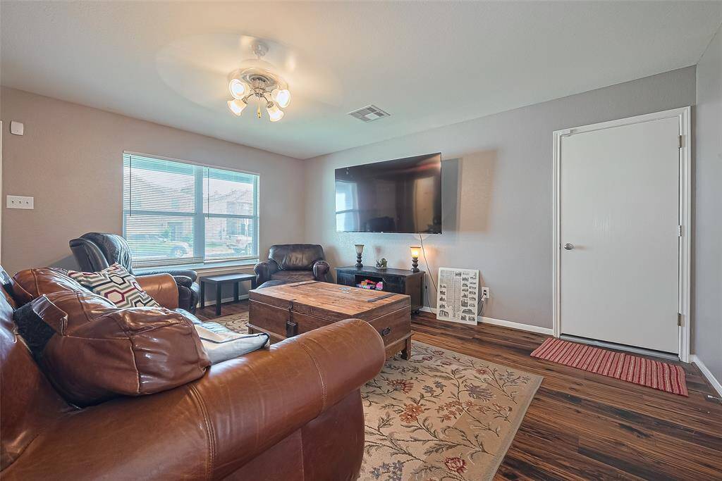 The door pictured in the living room provides garage access where the full sized washer and dryer are located.