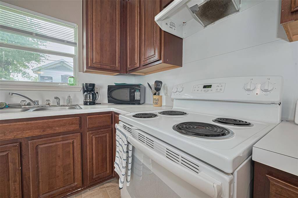 The kitchen has a four burner stove and venthood.