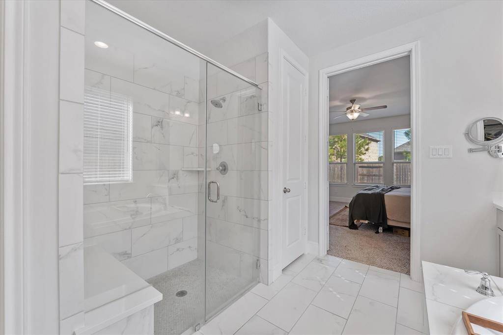 Primary ensuite bath with large format tile and frameless glass shower