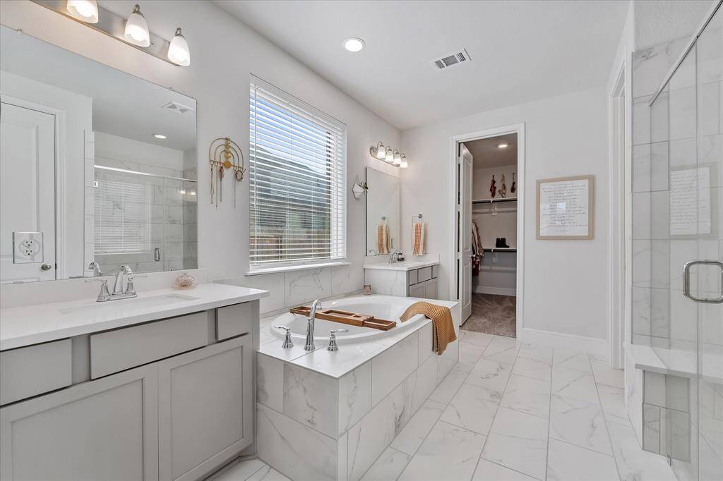 Primary ensuite bath with large format tile and frameless glass shower