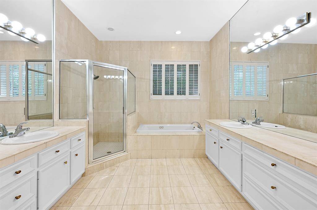 Amazing primary en-suite bathroom offers separate vanity sinks, stand in shower and soaker tub!