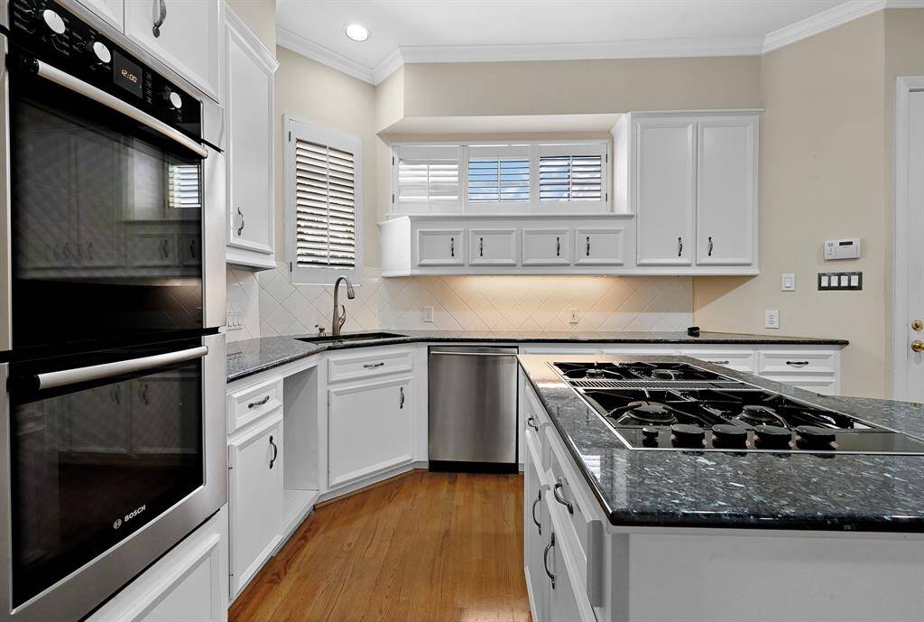 Useful and beautiful kitchen showcases the built-in cabinets, double ovens and gas range!