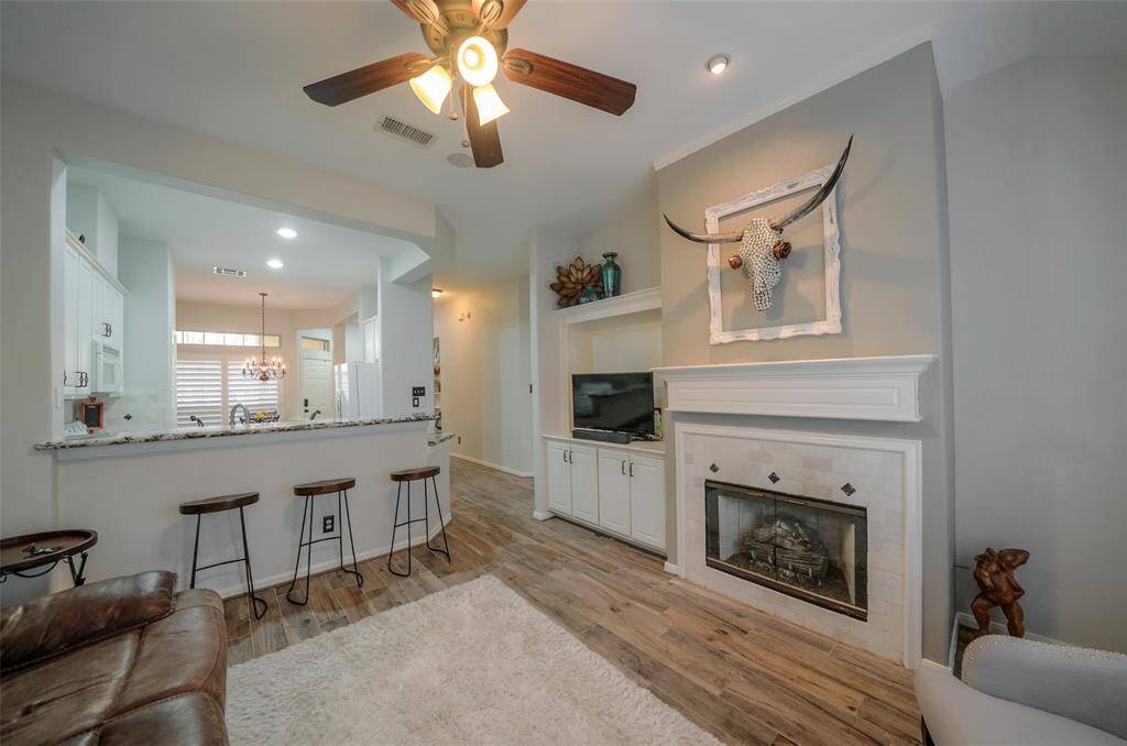 Family room view into the kitchen with a long breakfast bar in between. TV, and all other items seen, will be included in the lease.