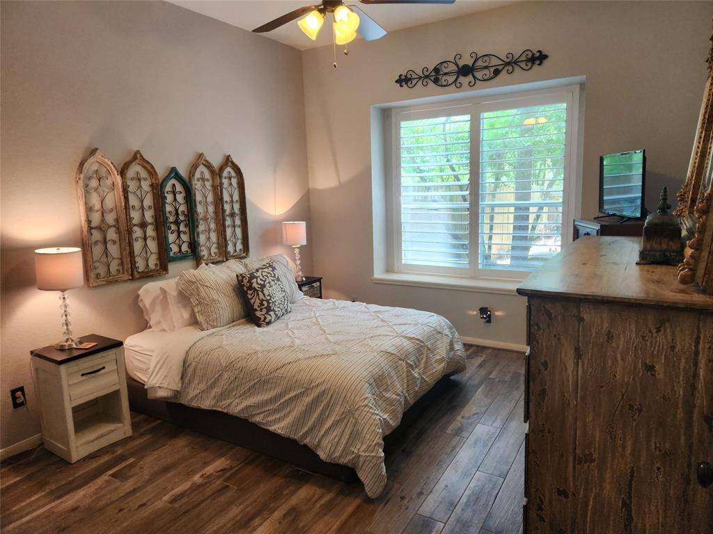 Master bedroom is in the back of the home and features a queen bedroom set, oversized dresser, plantation shutters and a window seat with a view of the pretty backyard.