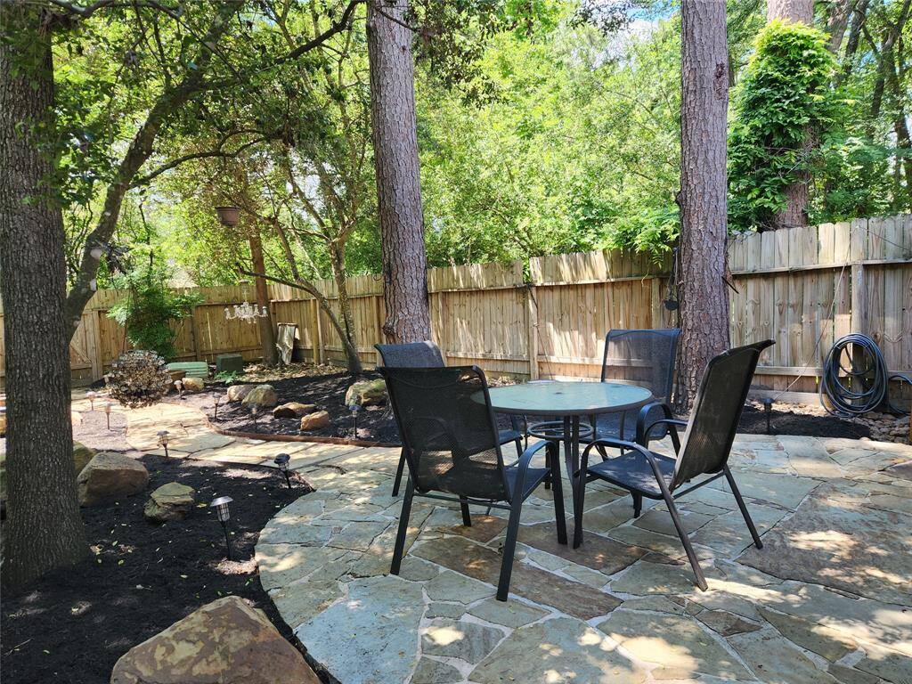 Lovely private backyard patio area that features a dining table and gas grill for your use.