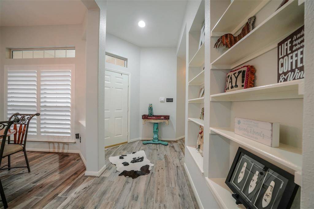 View towards the front entrance and features a wall of built-in shelves.
