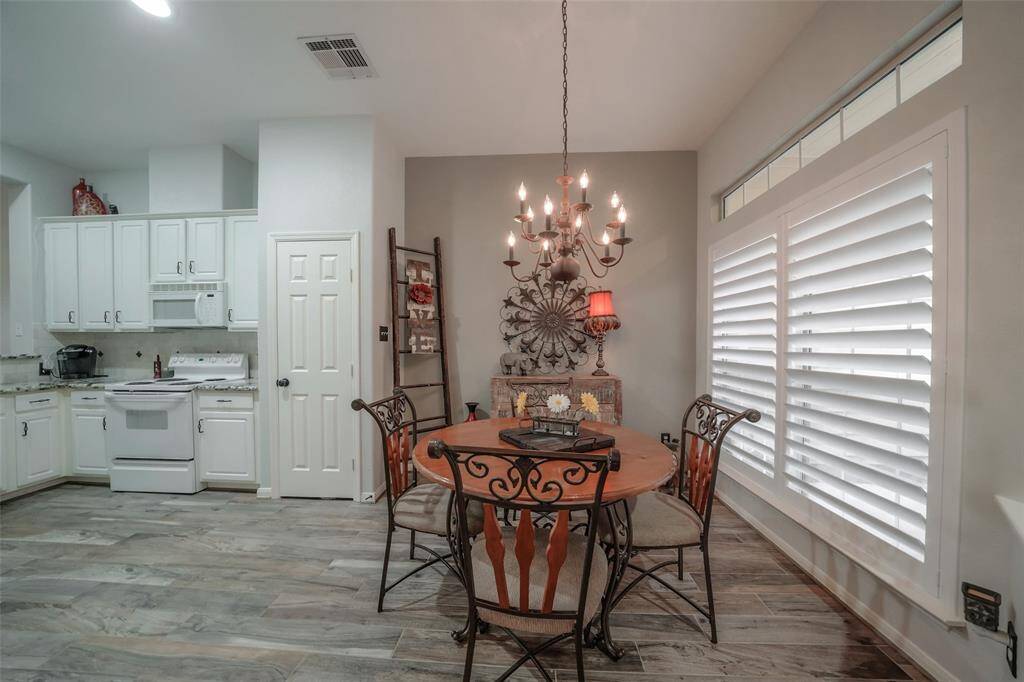 Kitchen/ dining combination features plantation shutters, an attractive dining table and stylish accessories.