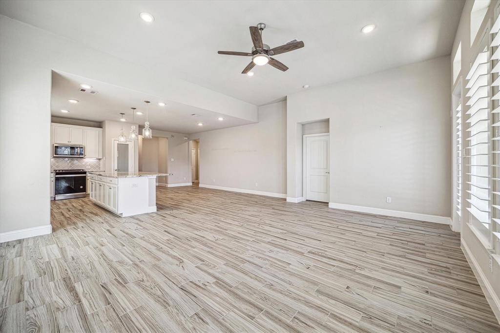 This open-concept living space seamlessly blends the kitchen, dining, and living areas, creating a bright and inviting atmosphere.