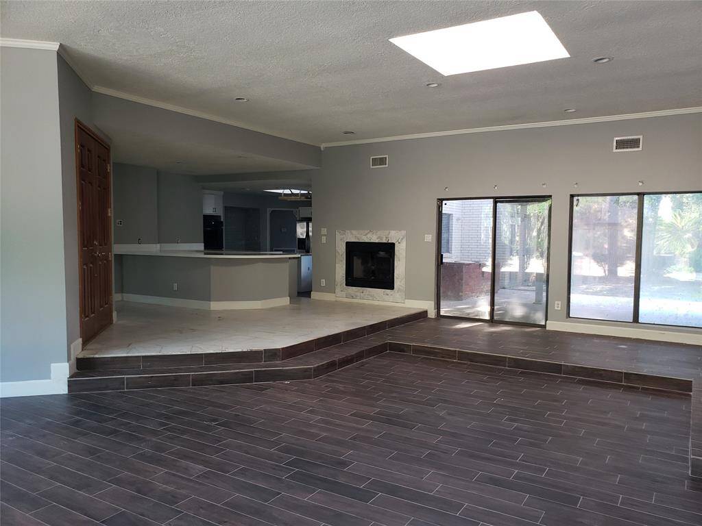 Living room with view large wet bar and quartz countertop. View of back covered patio