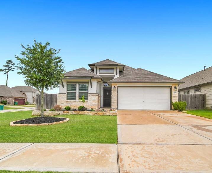 Front view of the home with manicured lawn and two-car garage.