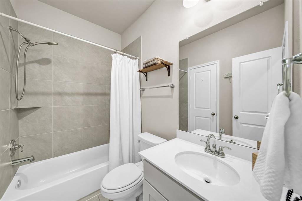Secondary bathroom with tub/shower combo and modern finishes.