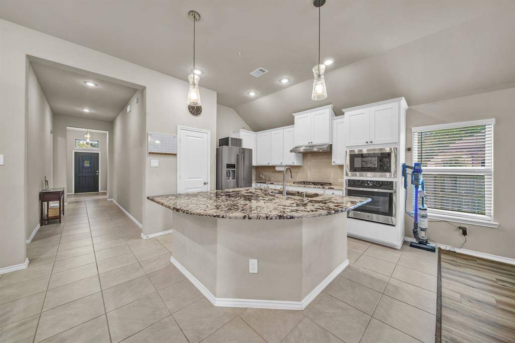 View of kitchen island and entry hallway from the main living space.