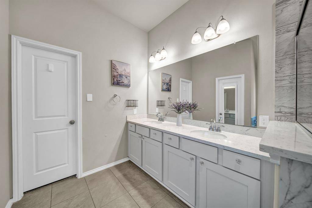 Double vanity in primary bathroom with elegant finishes.