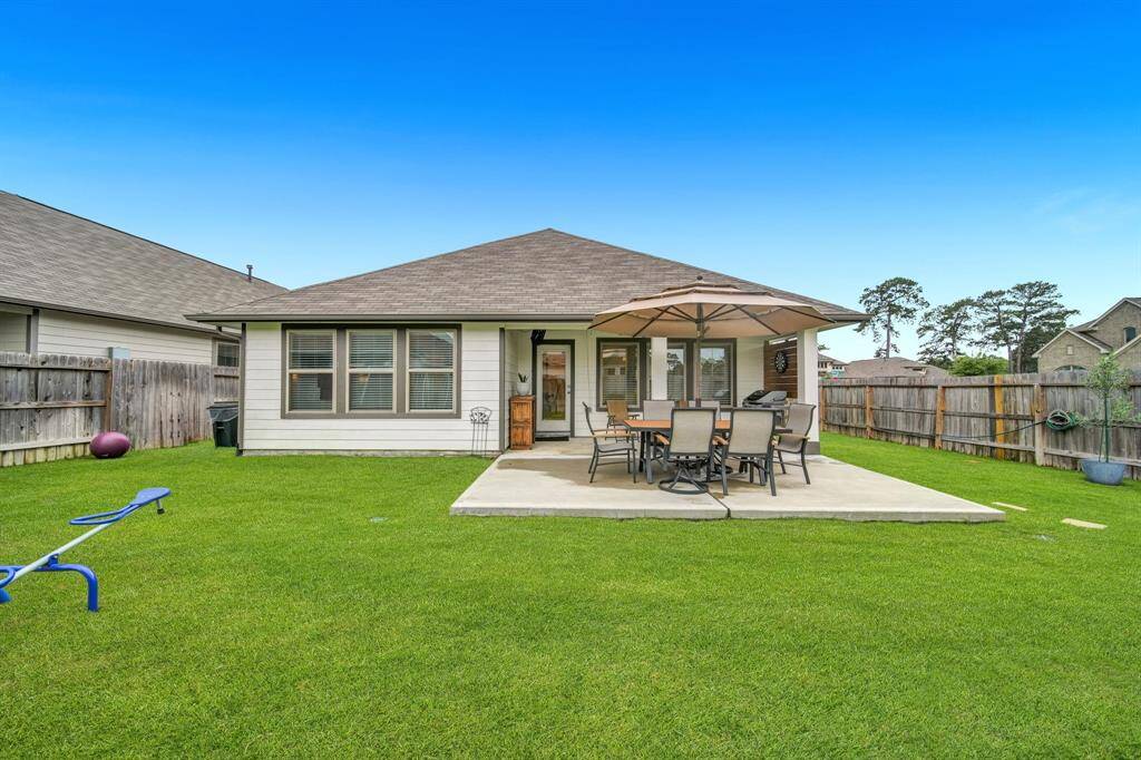 Large fenced yard with a playset, patio, and plenty of room to roam.