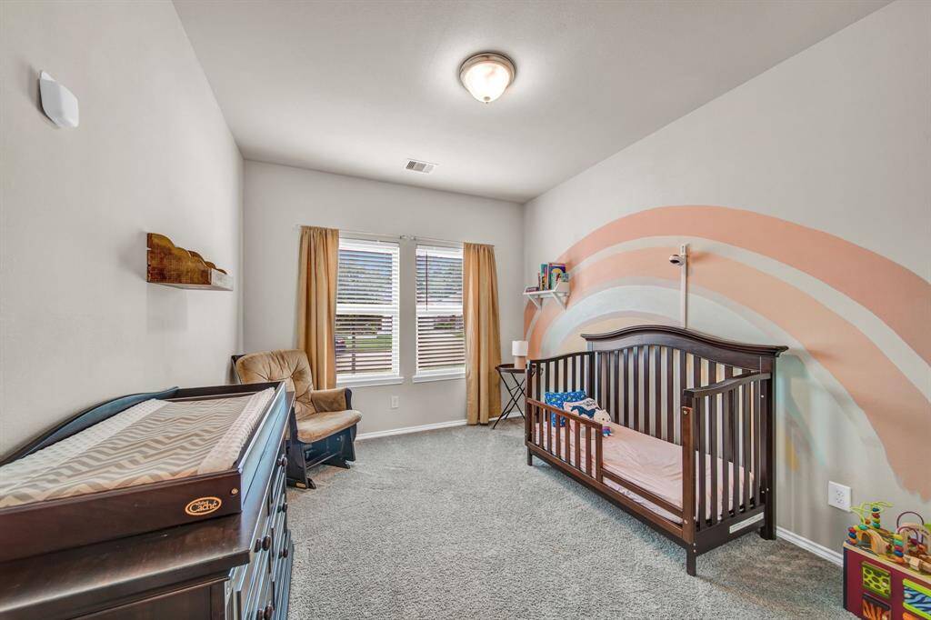 Cozy nursery with a rainbow accent wall and natural light