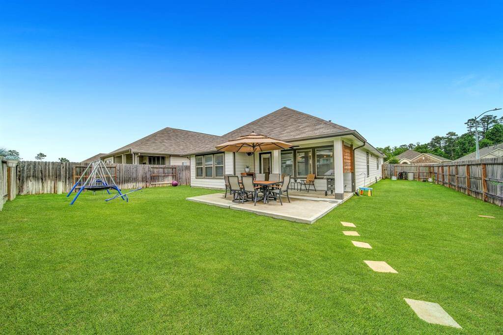 Large fenced yard with a playset, patio, and plenty of room to roam.