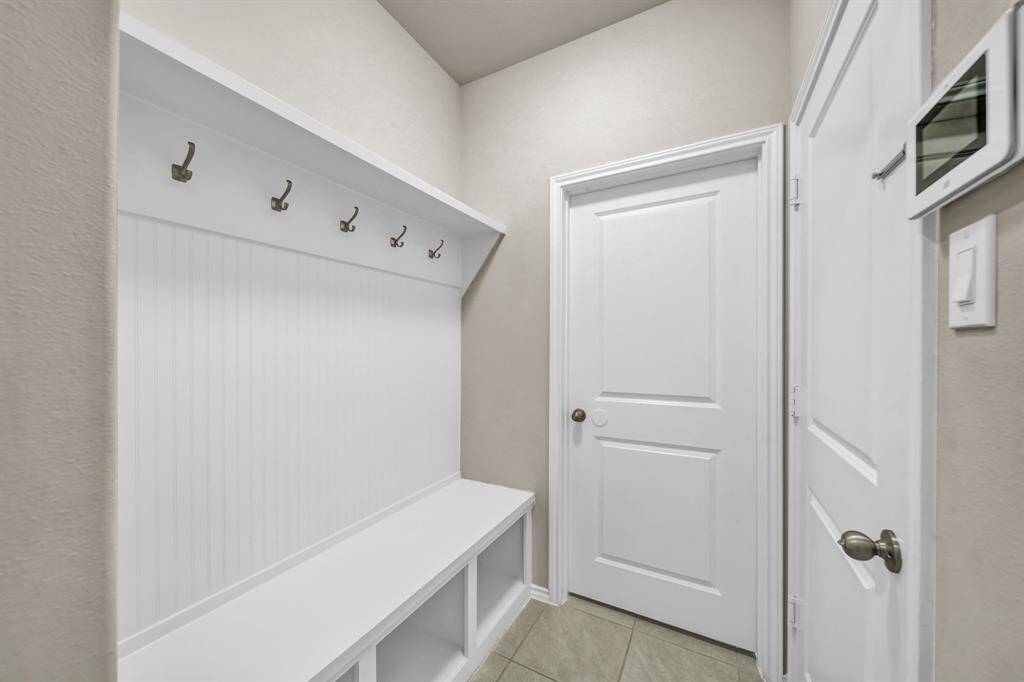 Mudroom with built-in bench and hooks for storage.