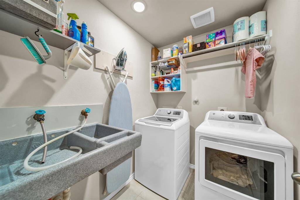 Laundry room with washer, dryer, utility sink, and built-in shelving
