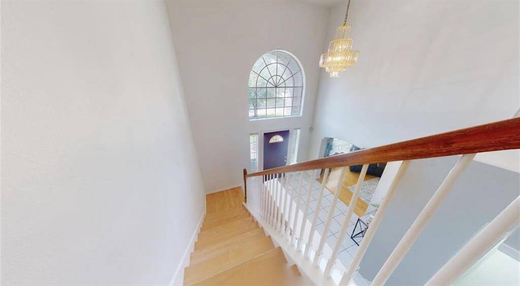 The elegant staircase features wooden steps and a classic railing design, creating a stunning focal point in the home’s entryway.