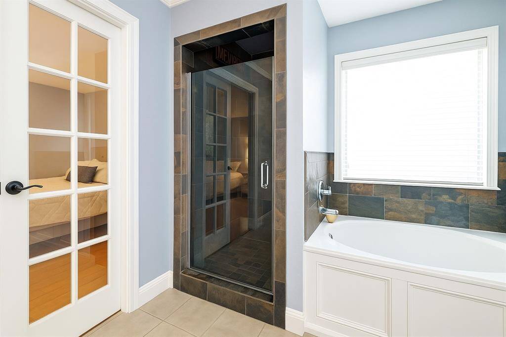 The master bathroom boasts an oversized walk-in shower with sleek tile finishes and ample space for a spa-like experience.