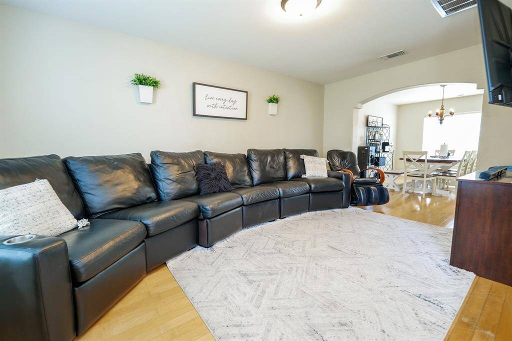The bright and open living room seamlessly flows into the dining area, creating an inviting space ideal for both everyday living and entertaining.
