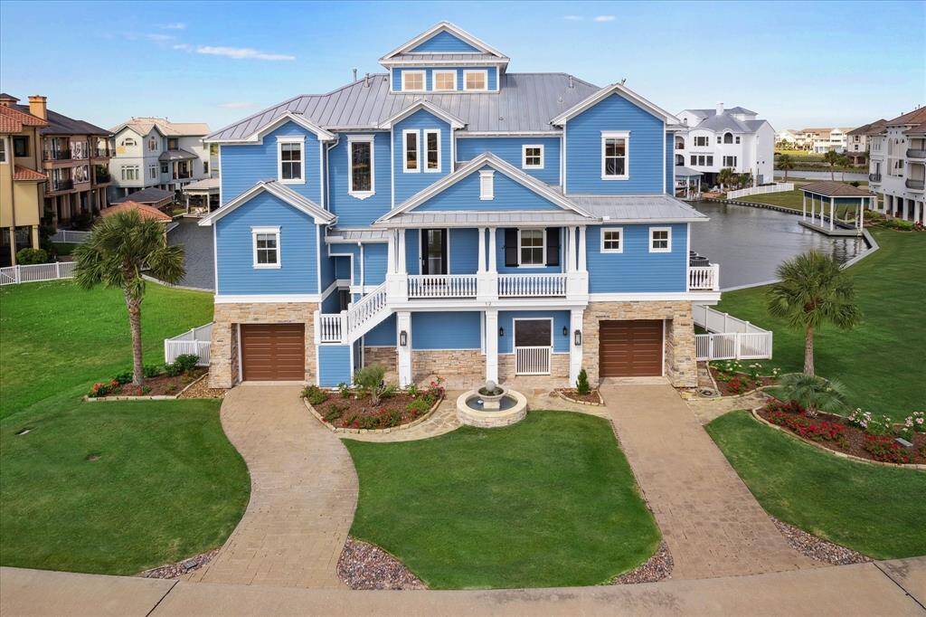 Welcome to 12 Big Torch. The home’s custom-designed exterior showcases distinctive features such as a stone fountain, paved driveways, high-impact windows, and its rare placement on a double homesite. From the moment you arrive, the welcoming front porch invites you to relax and take in breathtaking Galveston sunrises over the bay. This outdoor space leads seamlessly to a striking glass entry door that sets the tone for the elegance within
