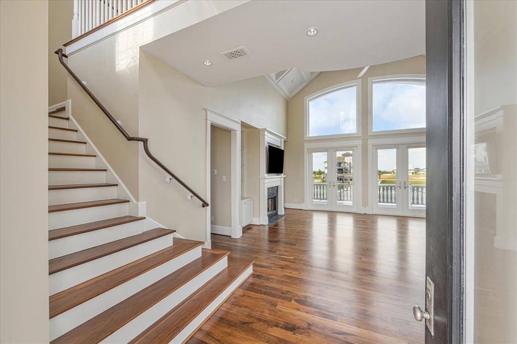 As you step through the glass front door, you're welcomed into a soaring two-story great room, where rich American walnut floors extend throughout the home