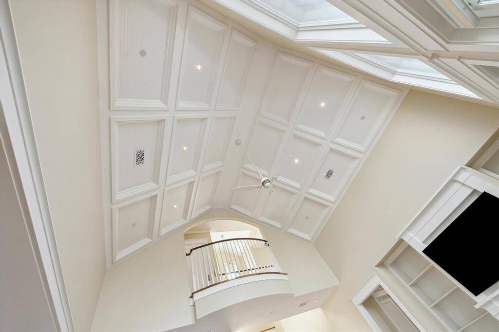 The custom-paneled cathedral ceiling adds an element of grandeur and sophistication, with its intricate design and soaring height that enhances the space’s openness and elegance. The rich panels create a stunning architectural feature, drawing the eye upward and creating a sense of awe in the room