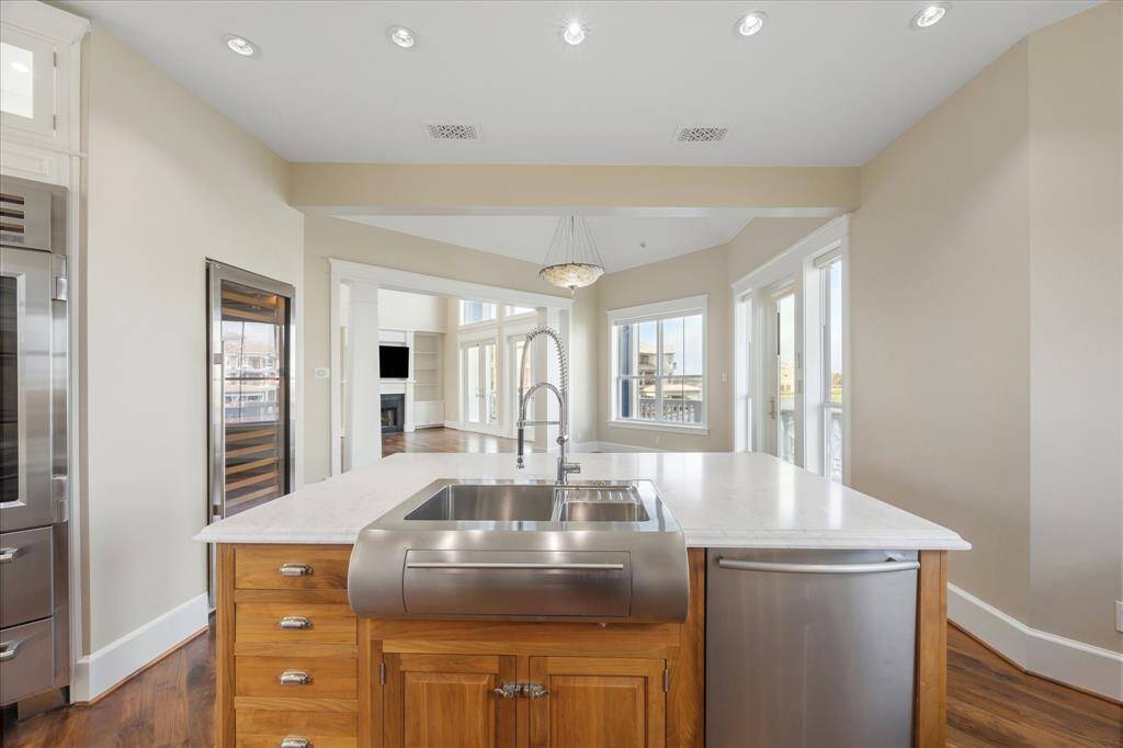 From the heart of the kitchen, enjoy a seamless sightline into the elegant dining area and spacious living room, where walls of windows frame breathtaking water views. Whether you're preparing a casual breakfast or hosting a sunset dinner, the open-concept layout keeps you connected to guests and the scenery alike