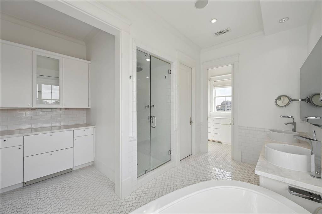 The primary en suite bath features a built-in coffee bar, two refrigerated drawers, and sleek glass shelving and cabinetry for organized storage. The spa-like shower includes a steamer and body sprays, allowing you to sit back, relax, and unwind while enjoying a rejuvenating experience in your own personal steam room