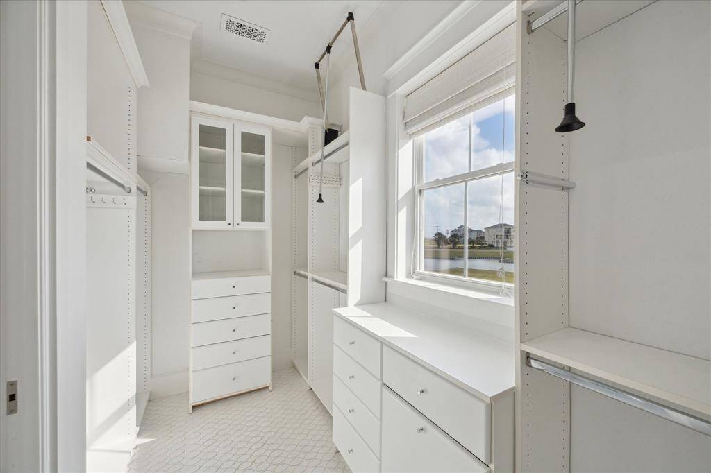 The primary closet features storage and shelving designed to provide both style and functionality. With plenty of storage space for clothing, accessories, and more, this closet offers a perfect blend of organization and luxury